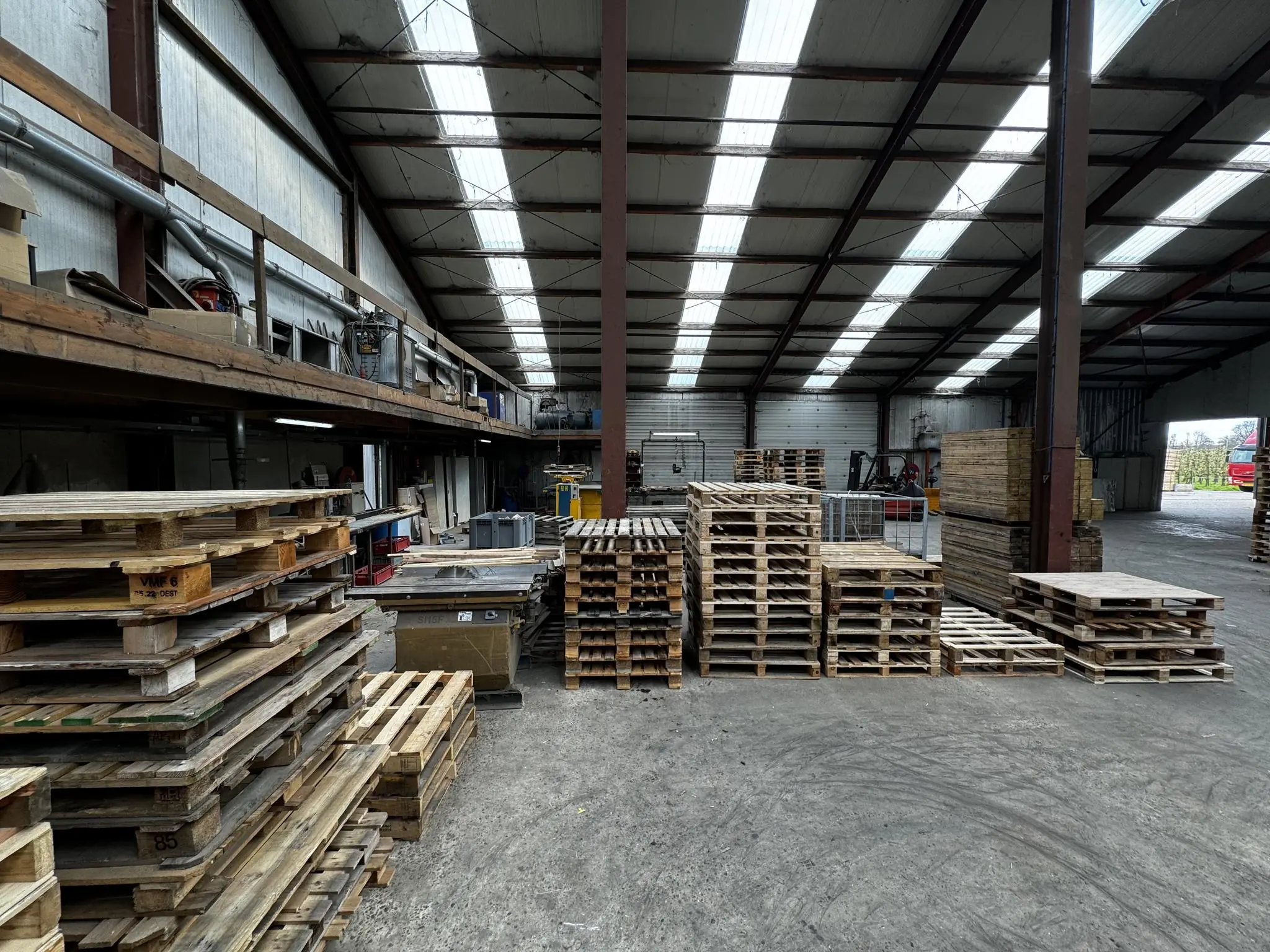 Stapel houten pallets in een ruime loods aan de Graaf van Lynden van Sandenburgweg.